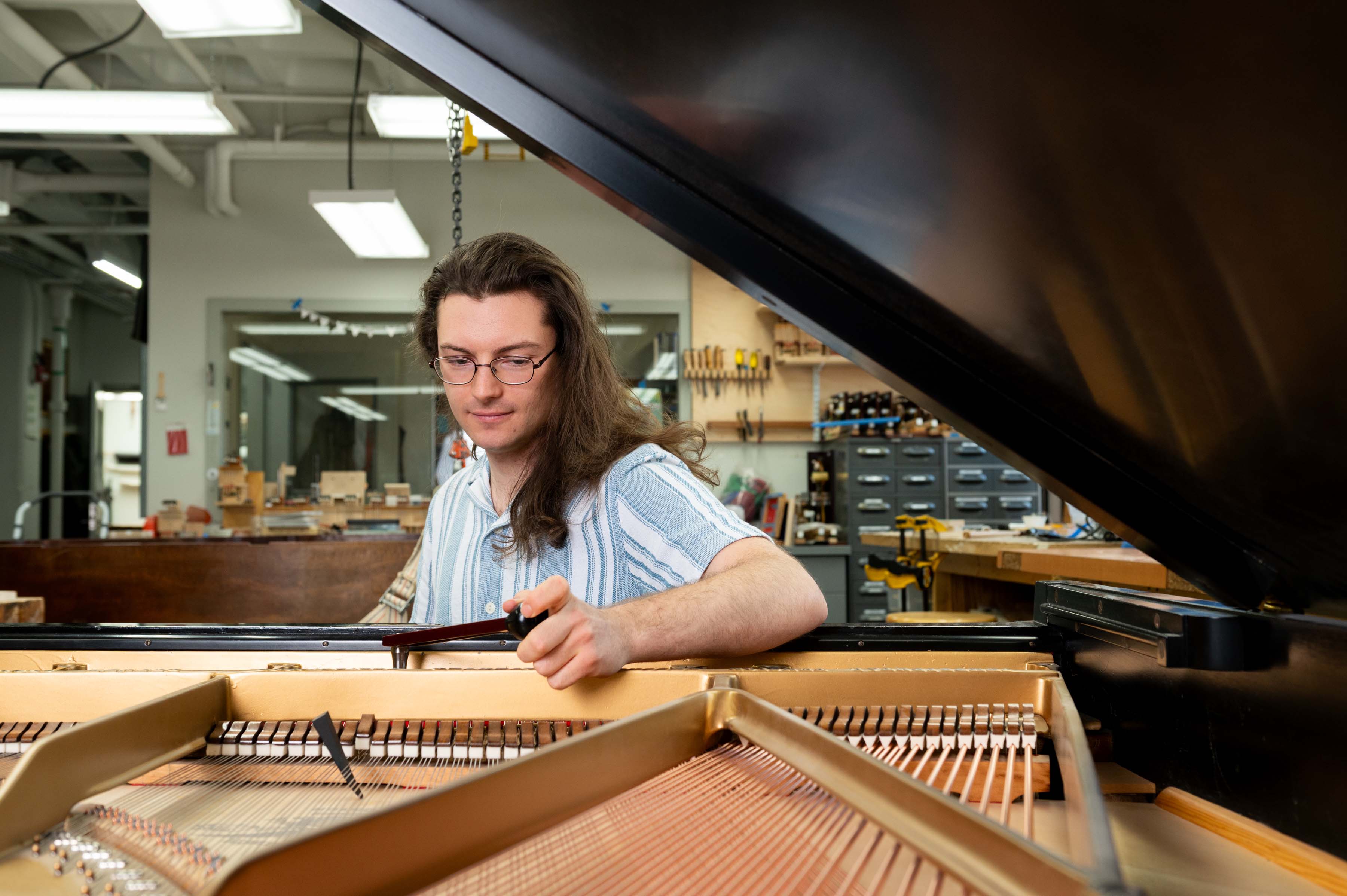 Technician tuning the action of a grand piano